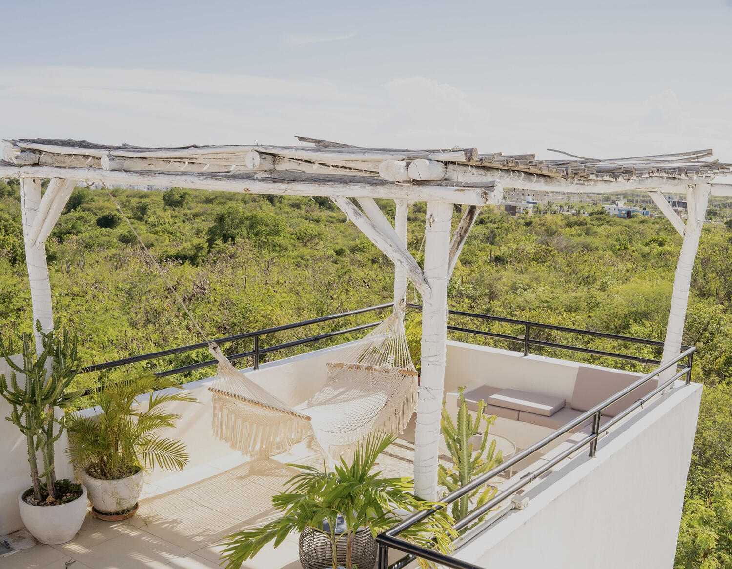 Rooftop con pérgola blanca y hamaca